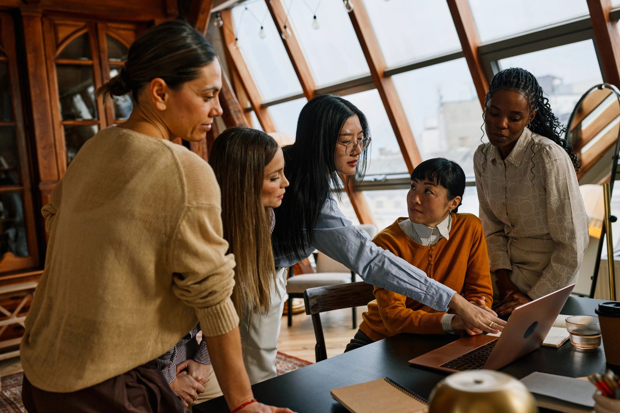 Marketing strategy team collaborating around a laptop